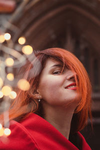 Close up attractive redhead lady and fairy lights on street portrait picture