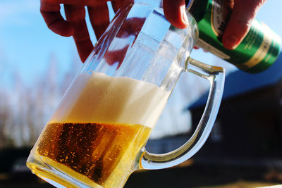 Close-up of hand holding beer glass