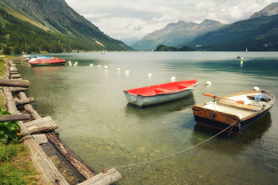 High angle view of boats moored in lake against mountains