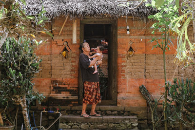 Rear view of woman standing against wall
