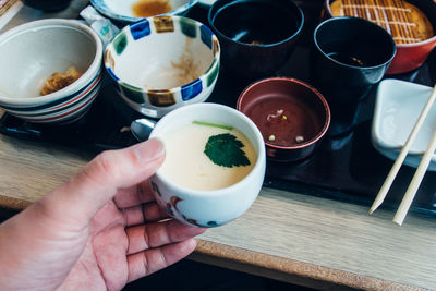 Midsection of person holding food on table