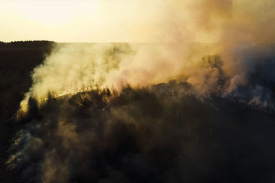 Smoke emitting from mountain against sky