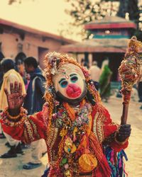 Man wearing traditional clothing with mask in town