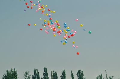 Low angle view of balloons flying in sky