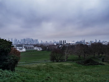 Trees and buildings in city against sky