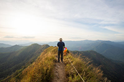 Rear view of man looking at mountain against sky