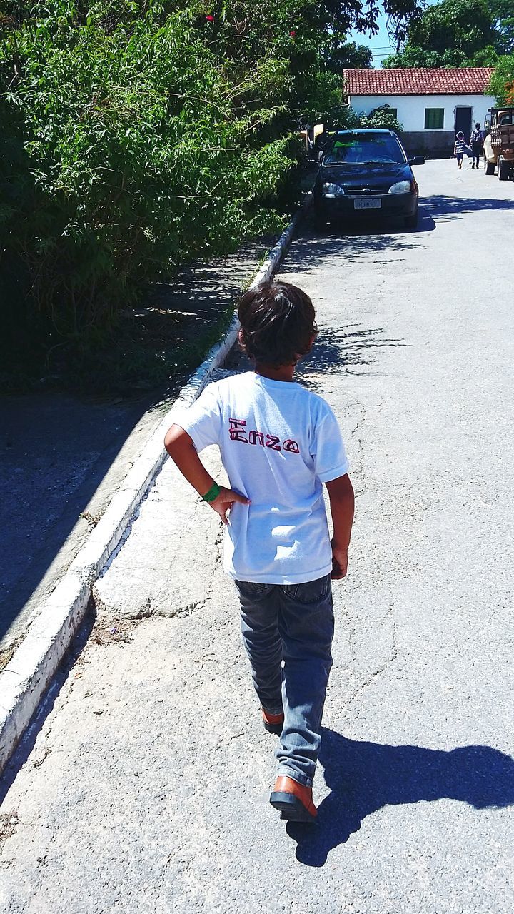 lifestyles, full length, rear view, casual clothing, walking, leisure activity, street, shadow, sunlight, tree, person, standing, footpath, road, men, sidewalk, outdoors, day