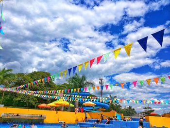 Low angle view of colorful umbrellas against cloudy sky