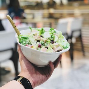 Close-up of hand holding salad in bowl
