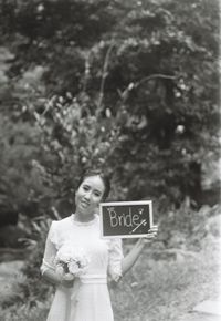 Portrait of woman standing against plants