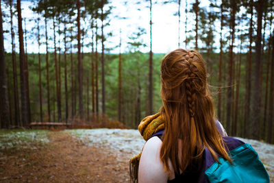 Rear view of woman standing in forest