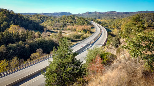 High angle view of road amidst trees against sky