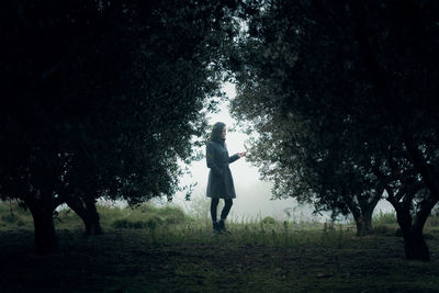 Rear view of woman standing on field