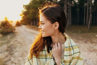 Portrait of smiling young woman looking away outdoors