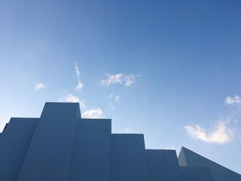 Low angle view of skyscrapers against blue sky