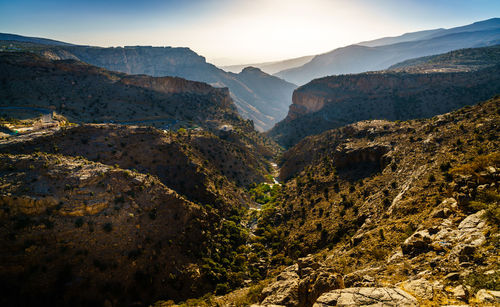 Scenic view of valley and mountains against sky