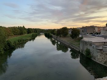 Scenic view of river against sky at sunset