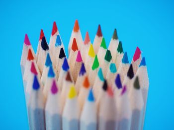 Close-up of colored pencils against blue background