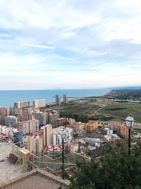 Scenic view of cityscape by sea against sky