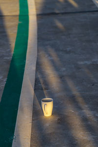 High angle view of coffee cup on footpath