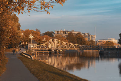 Bridge over river in city against sky