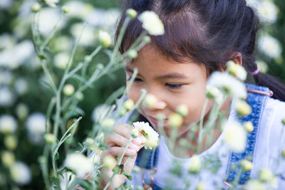 Cute girl smelling flower at park