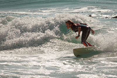 Rear view of woman surfing in sea