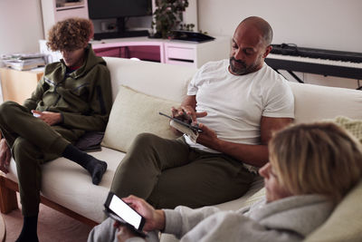 Family using smart phones in living room