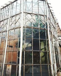 Low angle view of glass building against sky