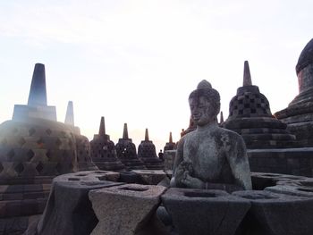 Statue of temple in building against sky