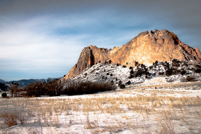 Scenic view of snow covered field and mountain against cloudy sky