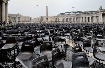 Empty chairs at st peter square against sky