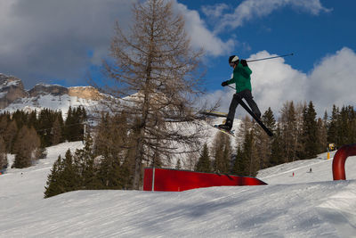 Low angle view of person paragliding on snow against sky