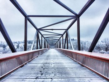 Footbridge against sky in city