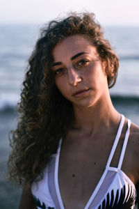 Portrait of young woman against sea