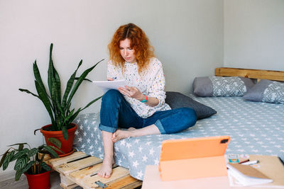 Adult attractive woman studying from home on online courses using tablet