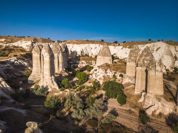 Rock formations on landscape against blue sky