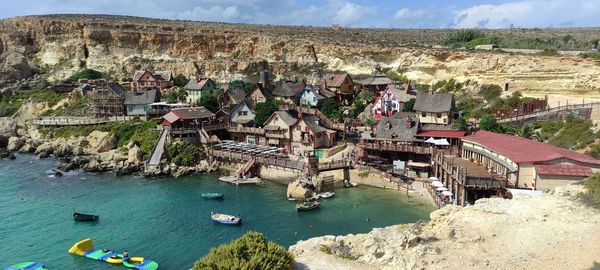 High angle view of townscape by sea against sky