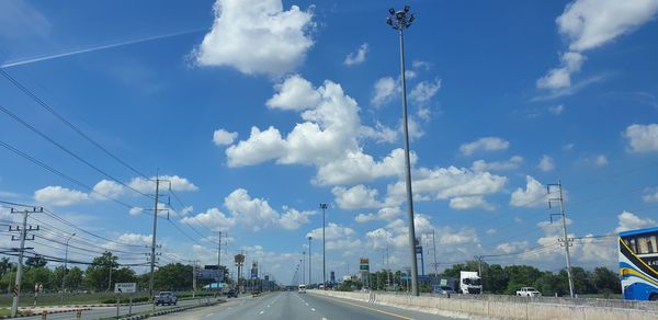 Cars on road against sky in city