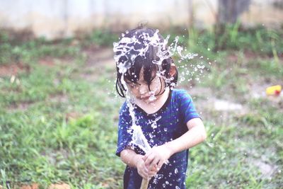 Girl holding hose on field