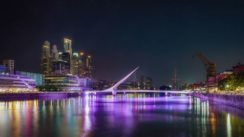View of illuminated bridge over river against cityscape