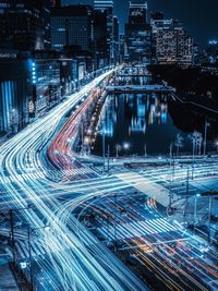 Light trails on city street by buildings at night