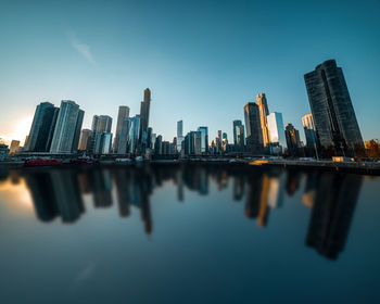 Reflection of buildings in city against sky
