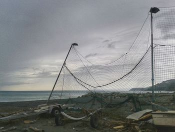 View of fishing net on beach against sky