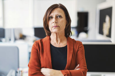 Portrait of businesswoman standing arms crossed in office