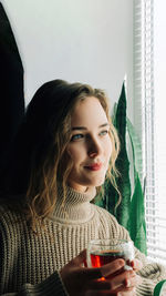 Portrait of young woman sitting at home