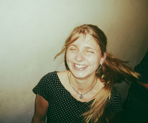 Smiling woman by wall at home