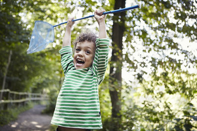 Portrait of smiling boy holding plant