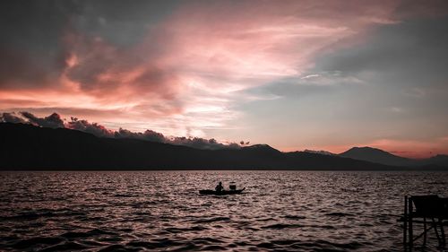 Scenic view of lake against sky and mountain during sunset