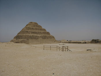 Scenic view of djoser pyramid in saqqara necropolis desert against clear sky